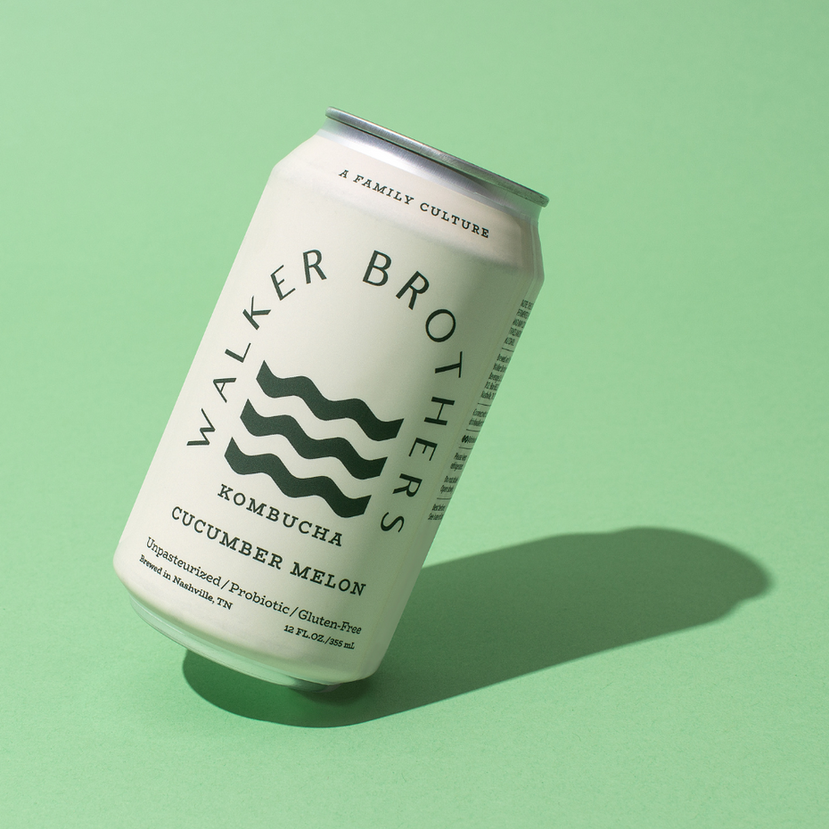 Can of Walker Brothers Kombucha Cucumber Melon flavor in front of a light green background. The can is slightly tilted to the right and features the Walker Brothers logo which has three wavy lines in green and text indicating it is a unpasteurized, probiotic, and gluten-free.